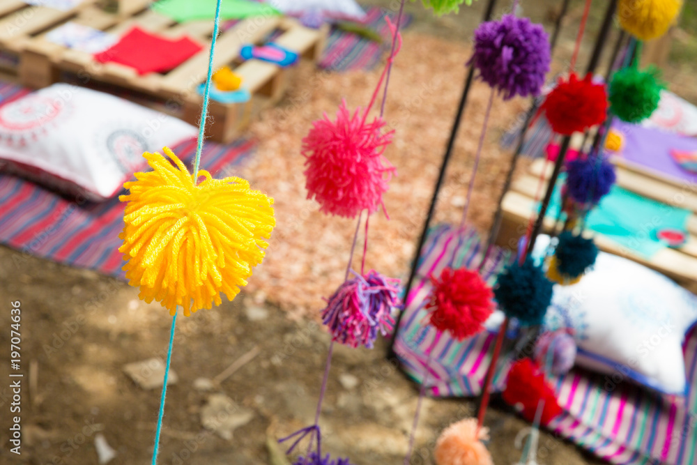 Colorful picnic party. Wool balls decor closeup with bokeh picnic tables. Birthday celebration concept.