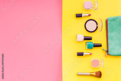 Decorative cosmetics for make up on pink and yellow desk background top view mock up
