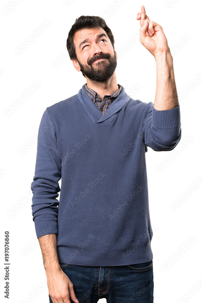 Handsome brunette man with beard with his fingers crossing on white background Handsome brunette man with beard with his fingers crossing on white background