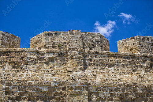 Ancient fortress wall close-up against a blue sky.