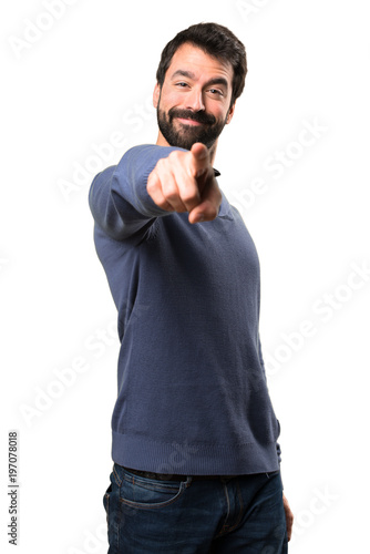 Handsome brunette man with beard pointing to the front on white background © luismolinero