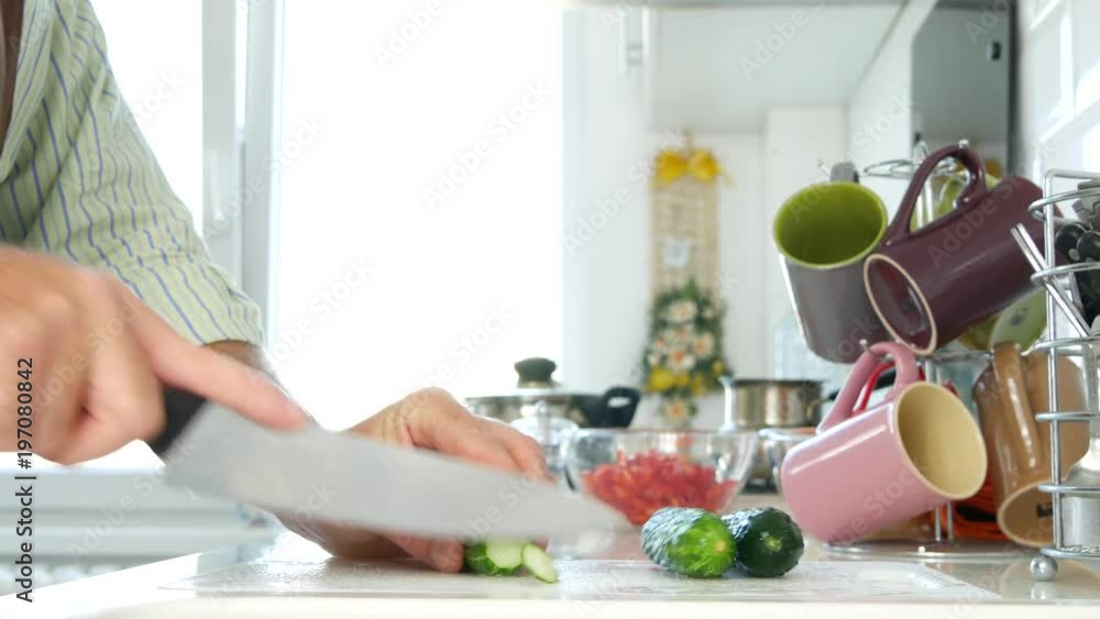 Man in Kitchen Cut Using Knife Round Slices of Fresh Cucumbers for Vegan Diet Man in Kitchen Cut Using Knife Round Slices of Fresh Cucumbers for Vegan Diet