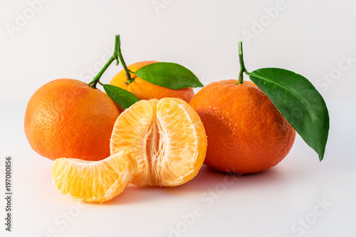 Whole tangerines or mandarines orange fruits and peeled segments isolated on white background