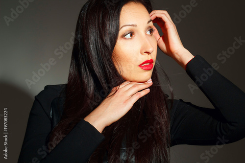 Portrait of young beautiful woman with red lipstick over dark background. Beauty portrait concept.