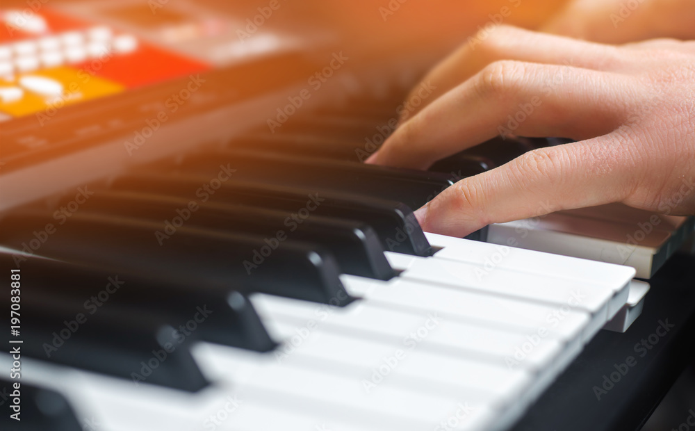 Obraz premium Close-up of a music performer's hand playing the piano, man's hand, classical music, keyboard, synthesizer, pianist