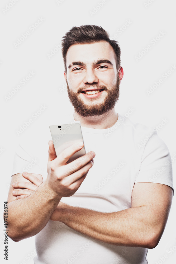 young man looking at his smart phone while text messaging isolated on white background young man looking at his smart phone while text messaging isolated on white background