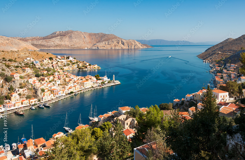 View of the village Gialos on the Greek island of Symi and the uninhabited islet Nimos, Dodecanese, Greece, and Turkey in the background