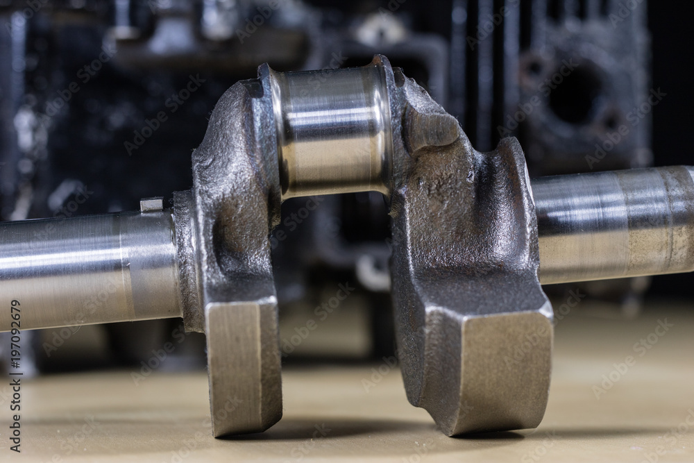 Crankshaft, piston and other parts of the internal combustion engine. Disassembled single-piston four-stroke engine on the workbench. Crankshaft, piston and other parts of the internal combustion engine. Disassembled single-piston four-stroke engine on the workbench.