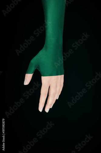 beautiful woman hand with half green make up tone in tone on green background, experimental photography photo