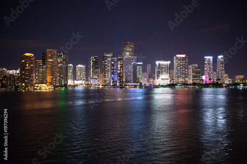 Miami city skyline panorama at night, usa. Skyscrapers illumination reflect on sea water in dusk. Architecture, structure, design. Building, construction, development. Wanderlust, travel, discovery
