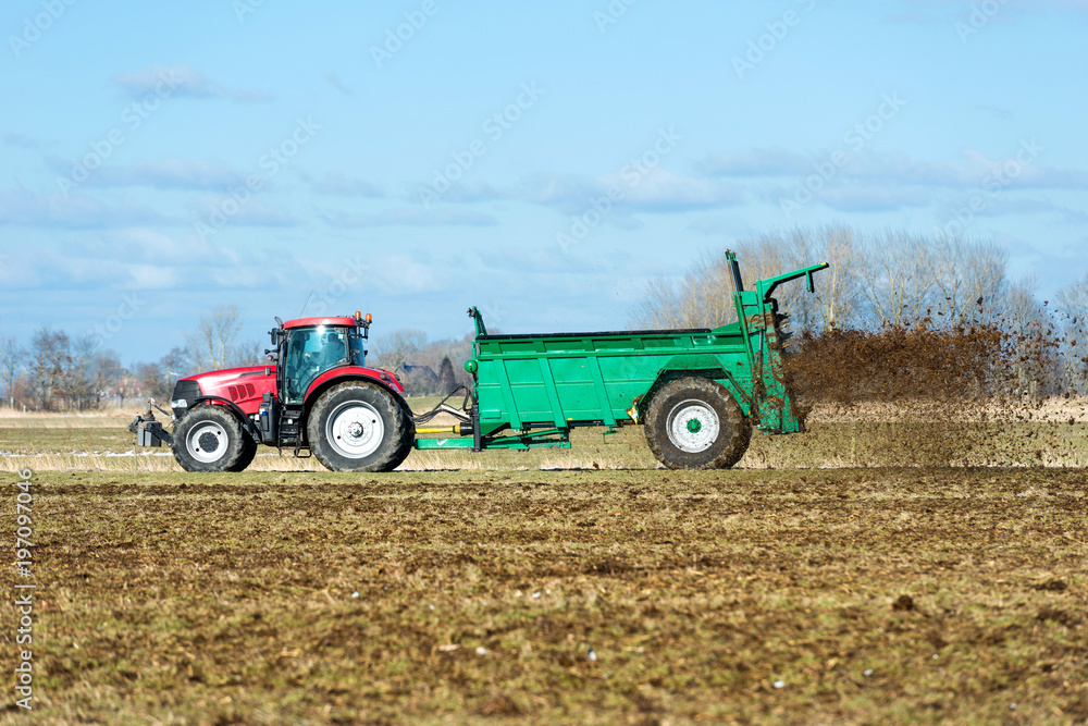 Fototapeta premium Tractor with manure spreader on the field - 1379
