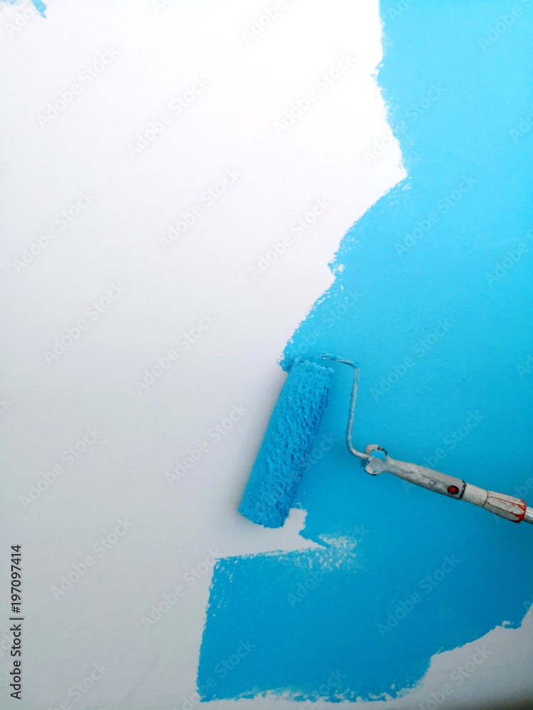 Malerrolle streicht weiße Wand mit heller blauer Farbe, Hintergrund Textfreiraum