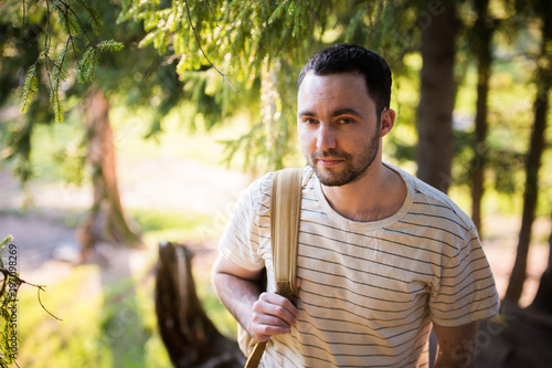 Smiling happy handsome man with beard in forest, mountains, park. Traveler Man relaxing . Travel Lifestyle hiking concept summer vacations outdoor. Bearded man.