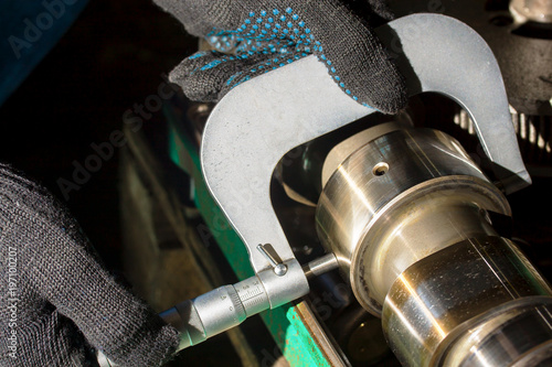 Foto Manual inspection of a crankshaft with a micrometer