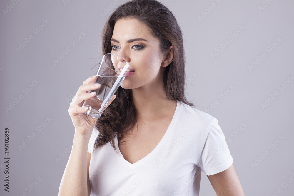 Young woman with beautiful smile is drinking water. Young woman with beautiful smile is drinking water.