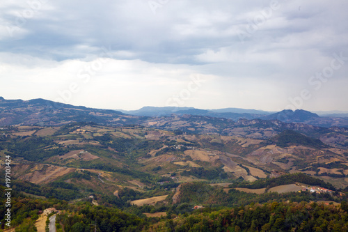 Fototapeta Naklejka Na Ścianę i Meble -  San Marino top view. Green meadow. Beautiful panoram of San Marino. Dark heavy sky, Italy.
