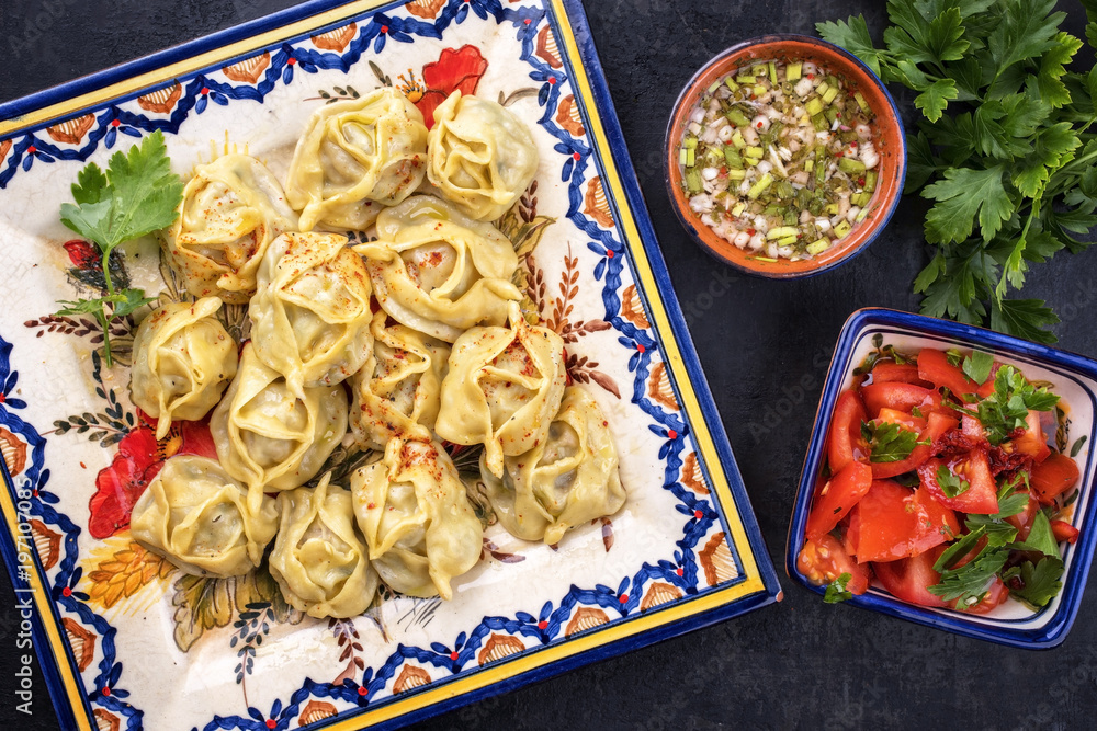 Traditional Kazakh manti steamed with mincemeat and tomato paprika salad as  top view on a plate Stock Photo | Adobe Stock