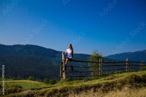 Tourist woman on top of mountains with blue sky. Woman enjoying free happiness in beautiful landscape. Travel concept