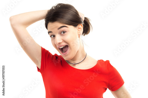 Portrait of a beautiful excited young woman wearing red t-shirt holding her hair, white background, studio shoot