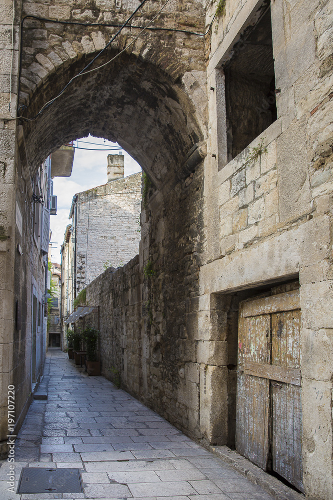 cobblestone street with an arch passage in old town Split , Croatia