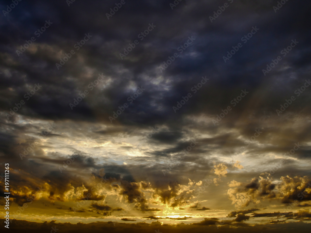 Dramatic sky with sun rays seep through clouds during sunset