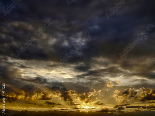 Dramatic sky with sun rays seep through clouds during sunset © Yuriy