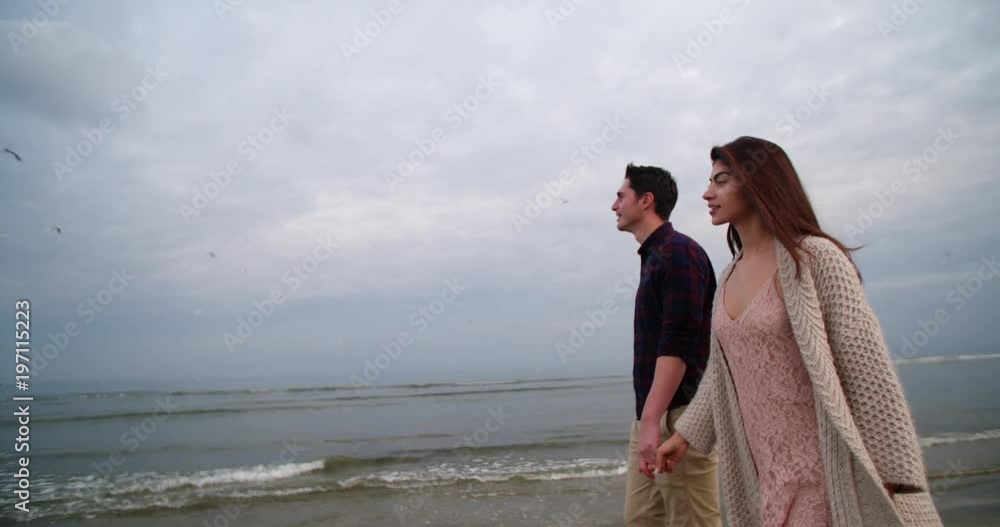 Young couple walking at the beach on a romantic date Young couple walking at the beach on a romantic date