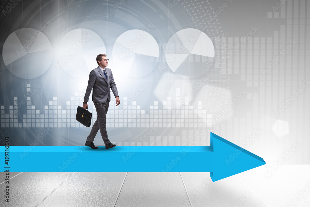 Businessman walking on arrow in business concept Businessman walking on arrow in business concept