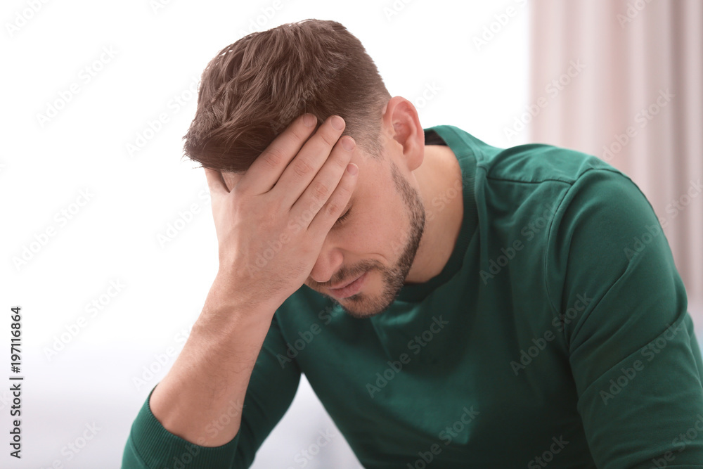 Young man suffering from headache at home Young man suffering from headache at home