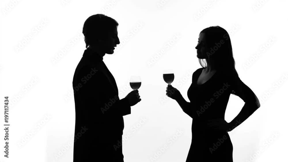 Silhouette of young couple drinking wine, getting acquainted, woman flirting