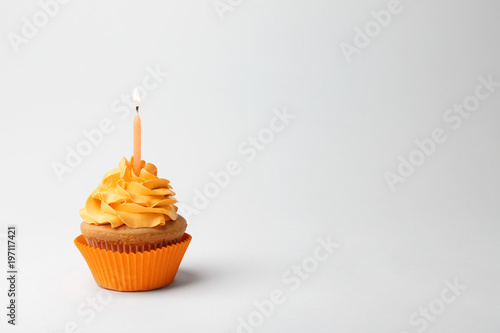 Birthday cupcake with candle on white background