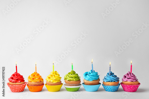 Birthday cupcakes with candles on white background