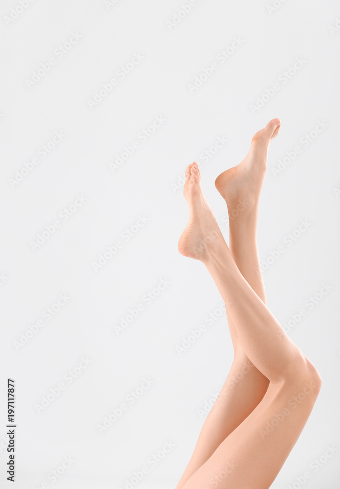 Young woman with beautiful silky skin on light background, closeup of legs Young woman with beautiful silky skin on light background, closeup of legs