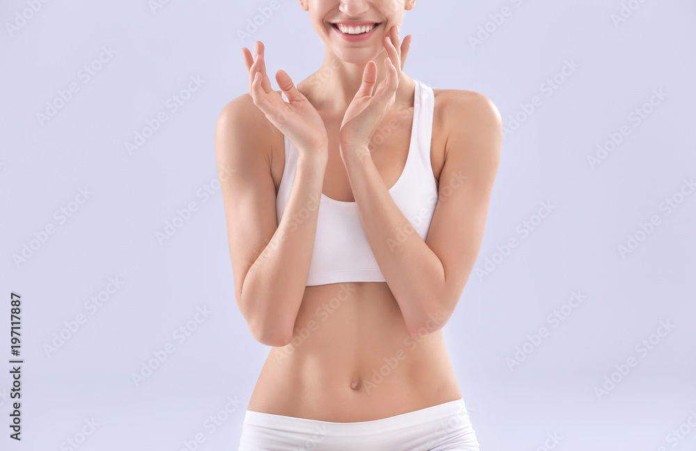 Obraz premium Young woman with silky skin on light background