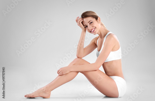 Young woman with beautiful silky body on light background