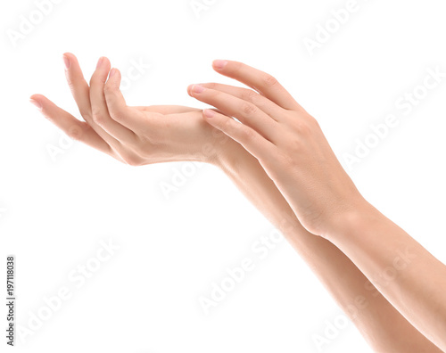 Young woman applying cream onto hands on white background
