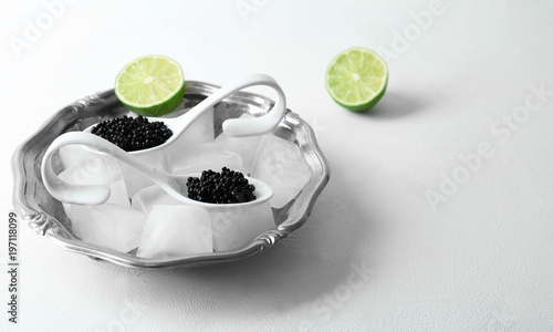Black caviar served with ice cubes on white background