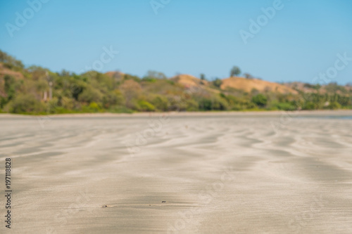 beach sand closeup with blurred landscape background