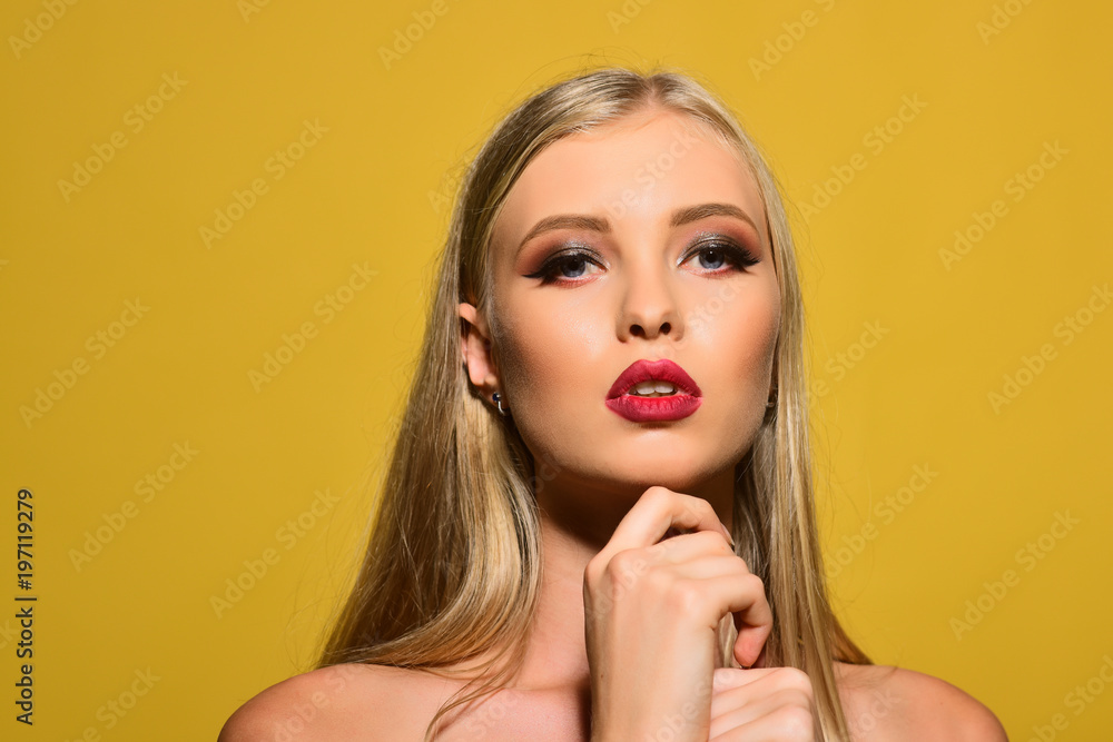 Fototapeta premium Spa woman. Skincare, haircare, spa, cosmetic, makeup, face lifting, fashion concept - sensual girl with fresh skin, red lips, perfect makeup, hand touches chin. Copy space for advertise beauty salon.