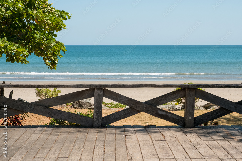 wooden terrace with beach, ocean  and blue sky background -