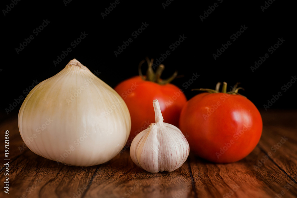 tomatoes, garlic and onion on a close-up table top tomatoes, garlic and onion on a close-up table top