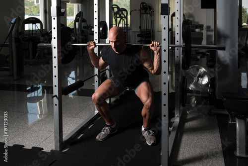 Athlete Doing Exercise For Legs With Barbell
