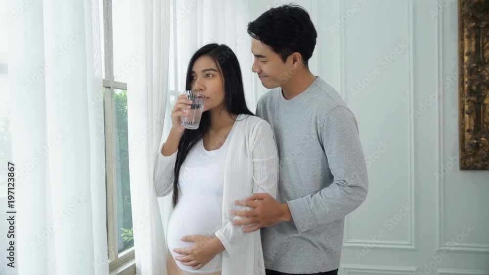 Young husband take care his pregnant wife with drink water Young husband take care his pregnant wife with drink water