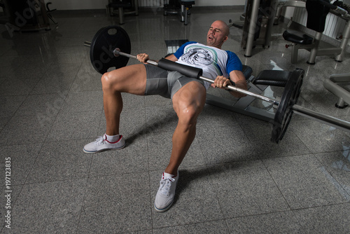 Man Athlete Exercising Glutes With Barbell