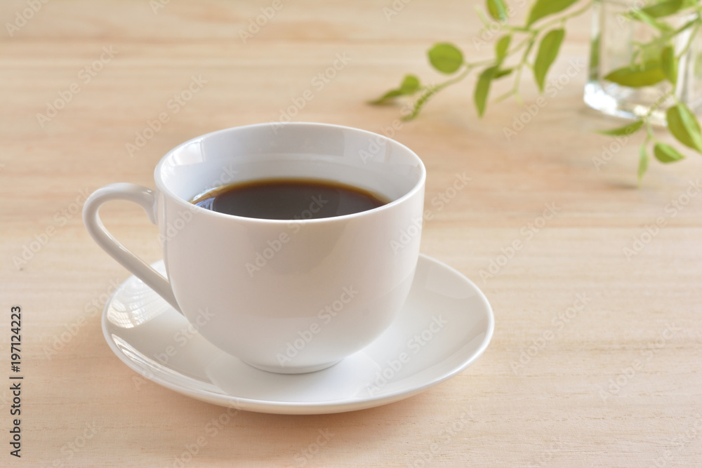 a cup of coffee on a wooden table
a cup of coffee on a wooden table