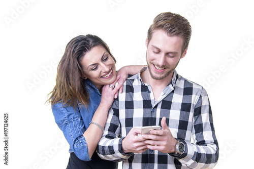 Young couple in love, married or in a relationship, browsing social media posts on a cell phone