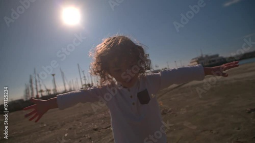 Young child throwing confettin on beach photo