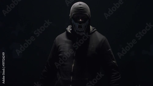 Portrait of masked hooligan with baseball bat on black background . Shot on RED cinema camera .