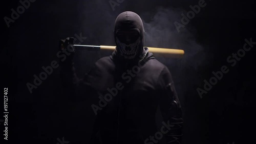 Portrait of masked hooligan with baseball bat on black background . Shot on RED cinema camera . photo