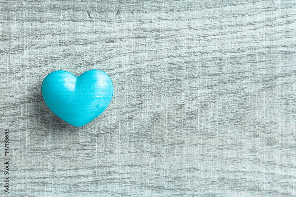 Blue heart shape over wooden table. Symbol of valentine day for background use. Concept of love and romance. Color filter. Blue heart shape over wooden table. Symbol of valentine day for background use. Concept of love and romance. Color filter.